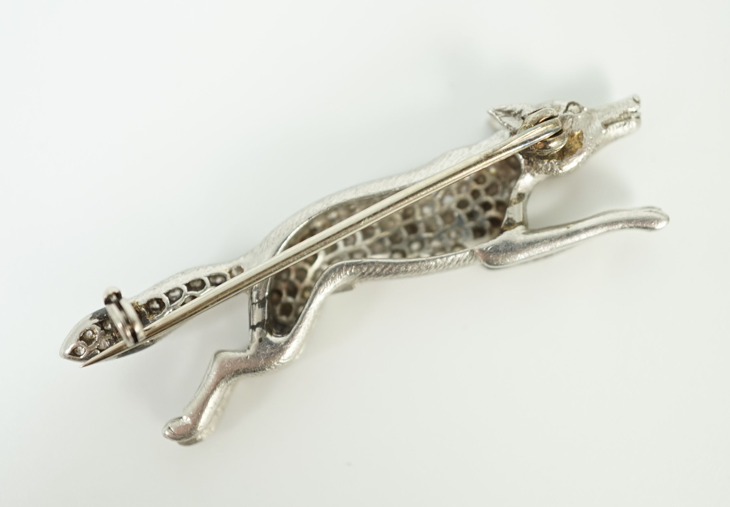 A Victorian style white gold, diamond encrusted and cabochon garnet set brooch, modelled as a running fox